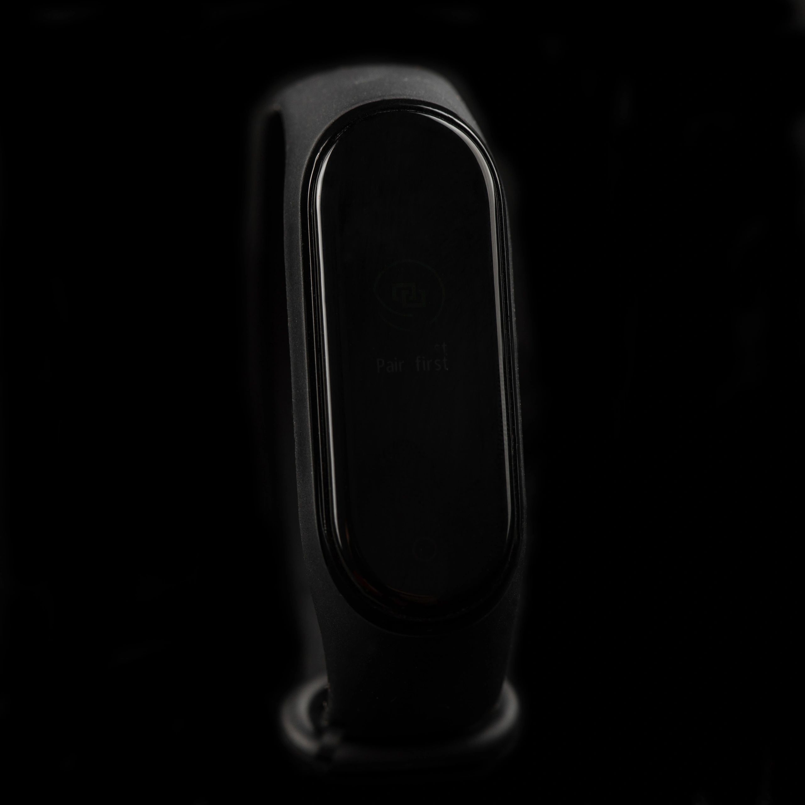 Close-up of a dark smartwatch on a black background, showing fitness/heart tracking interface.